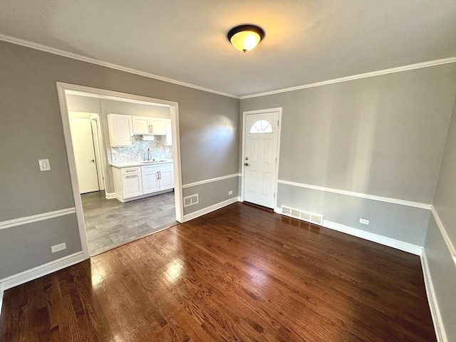 entrance foyer featuring ornamental molding, sink, and dark hardwood / wood-style floors