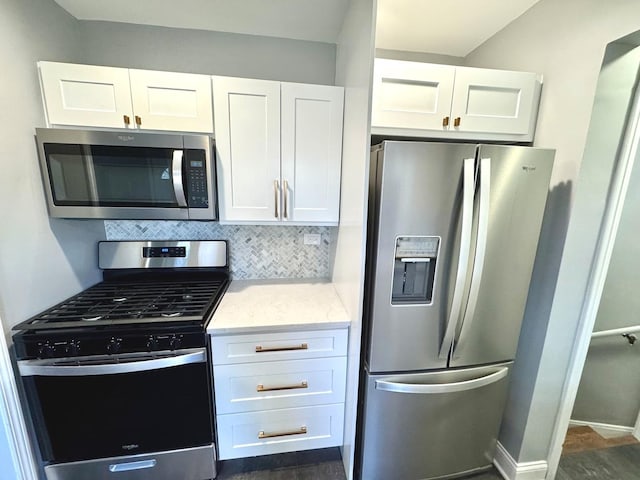 kitchen featuring tasteful backsplash, light stone counters, stainless steel appliances, and white cabinets