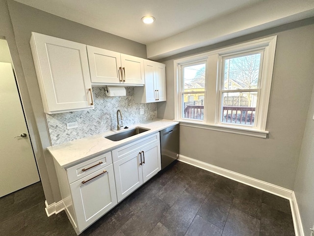 kitchen featuring white cabinetry, sink, decorative backsplash, and dishwasher