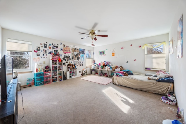 carpeted bedroom with ceiling fan and multiple windows