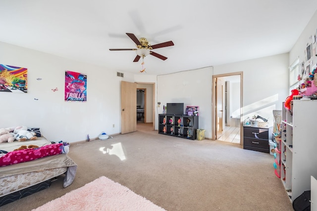 bedroom featuring ceiling fan, connected bathroom, and light colored carpet