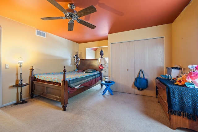 bedroom featuring light colored carpet, a closet, and ceiling fan