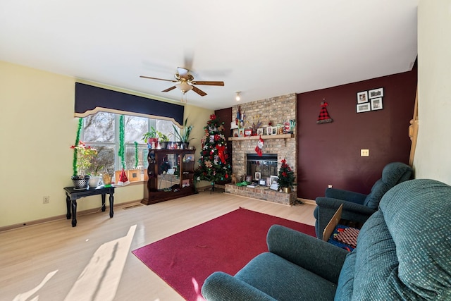 living room with ceiling fan, a brick fireplace, and hardwood / wood-style floors