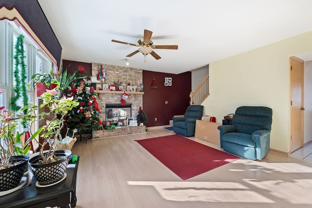 living room with hardwood / wood-style flooring, ceiling fan, and a fireplace