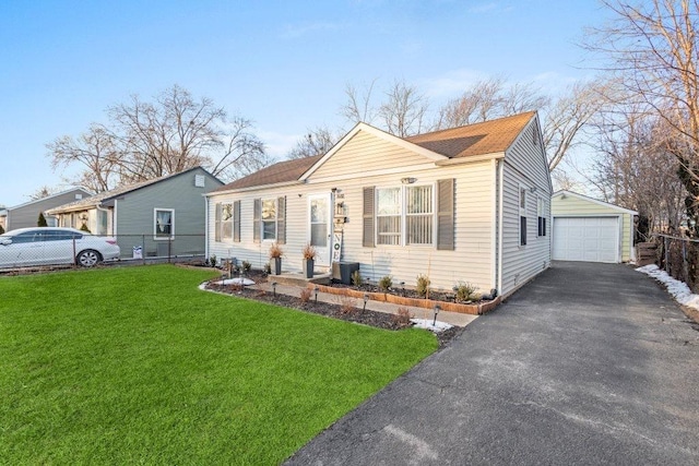 view of front of home with a garage, a front lawn, and an outbuilding