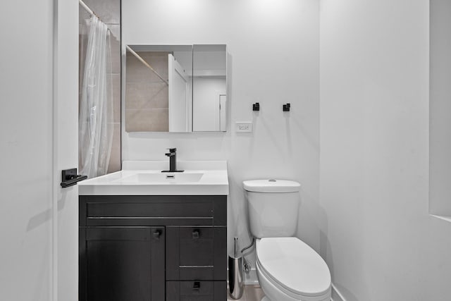 bathroom featuring walk in shower, vanity, and toilet