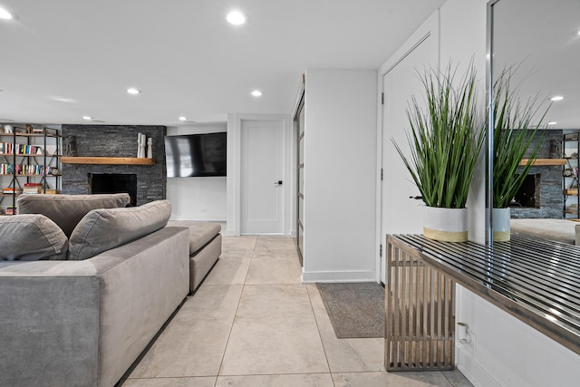 living room featuring light tile patterned flooring and a stone fireplace