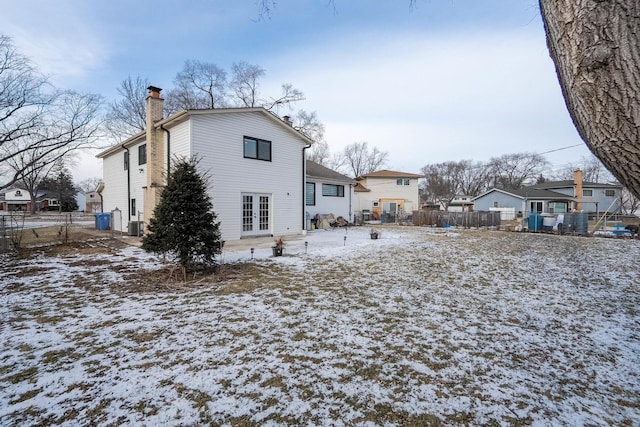 snow covered house featuring french doors