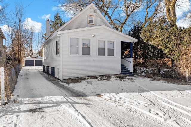 view of front facade with a garage and an outbuilding