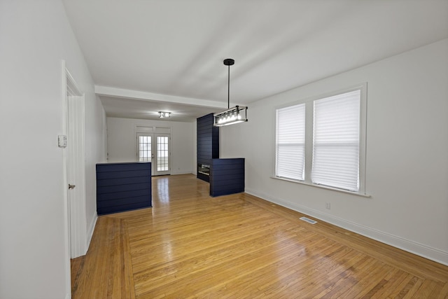 unfurnished dining area with wood-type flooring and french doors