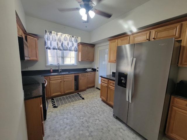 kitchen featuring ceiling fan, stove, stainless steel fridge, and sink