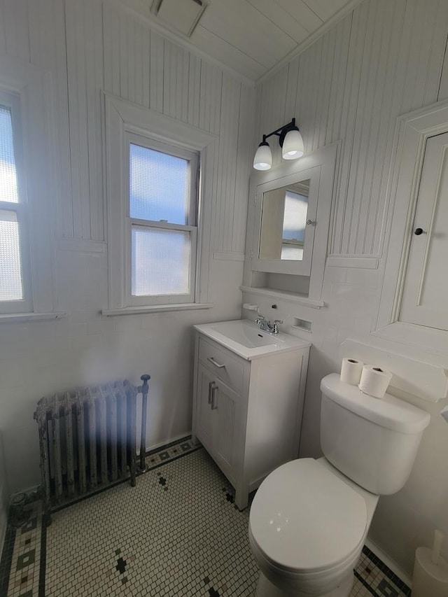 bathroom featuring plenty of natural light, tile patterned floors, radiator heating unit, and vanity