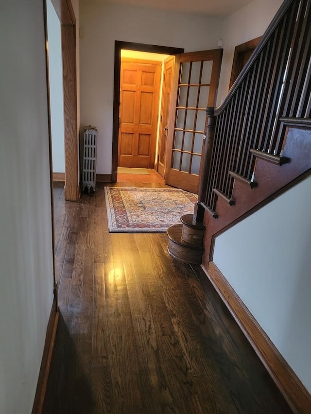 hallway with radiator and dark hardwood / wood-style flooring