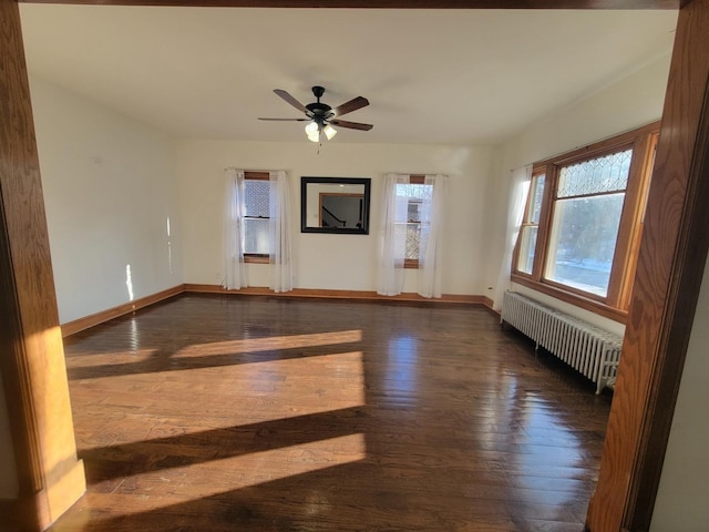 unfurnished room with ceiling fan, radiator, and dark hardwood / wood-style floors