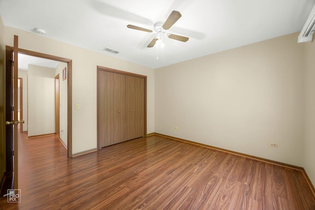 unfurnished bedroom with wood-type flooring, ceiling fan, and a closet