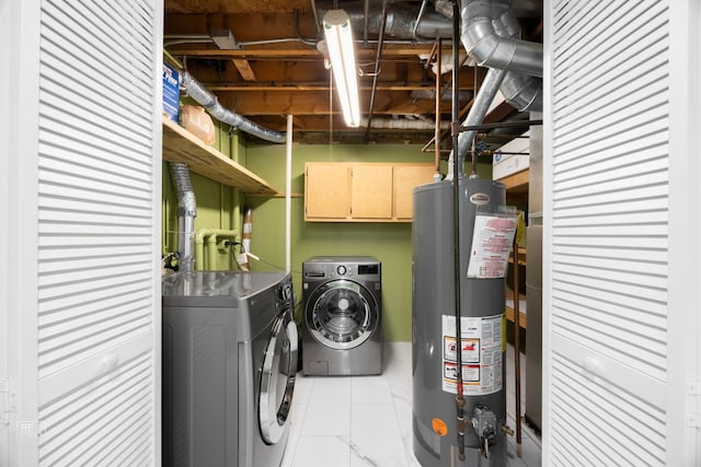 clothes washing area with washer and clothes dryer, light tile patterned floors, gas water heater, and cabinets