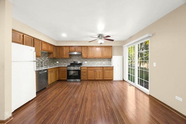 kitchen featuring appliances with stainless steel finishes, sink, backsplash, dark hardwood / wood-style flooring, and ceiling fan