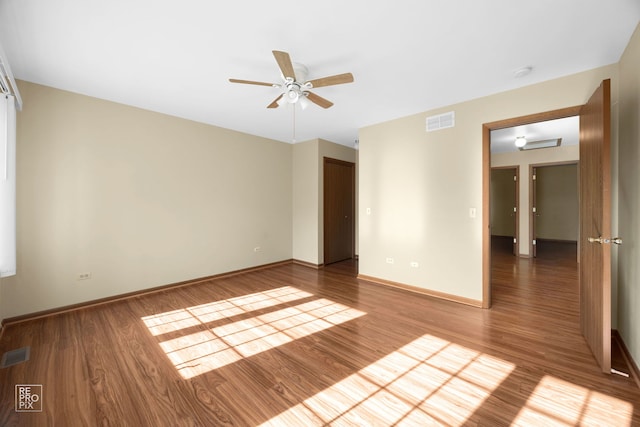 empty room with hardwood / wood-style floors and ceiling fan