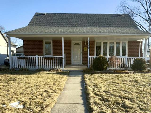 view of front facade featuring a front yard and covered porch