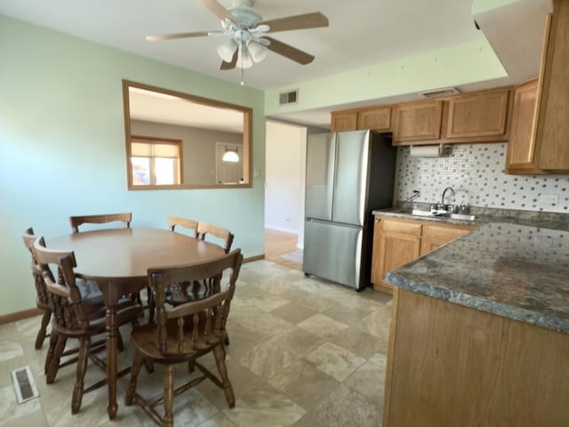 kitchen with tasteful backsplash, sink, stainless steel fridge, and ceiling fan