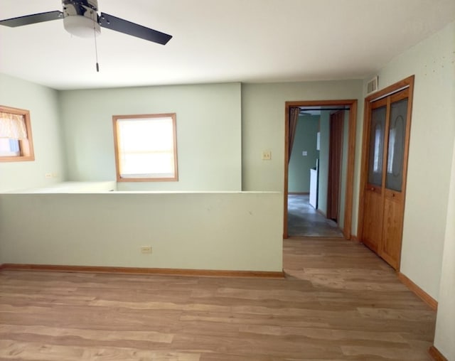 spare room featuring plenty of natural light, light hardwood / wood-style floors, and ceiling fan