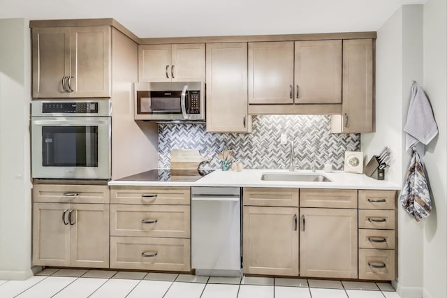 kitchen with sink, backsplash, appliances with stainless steel finishes, and light tile patterned flooring