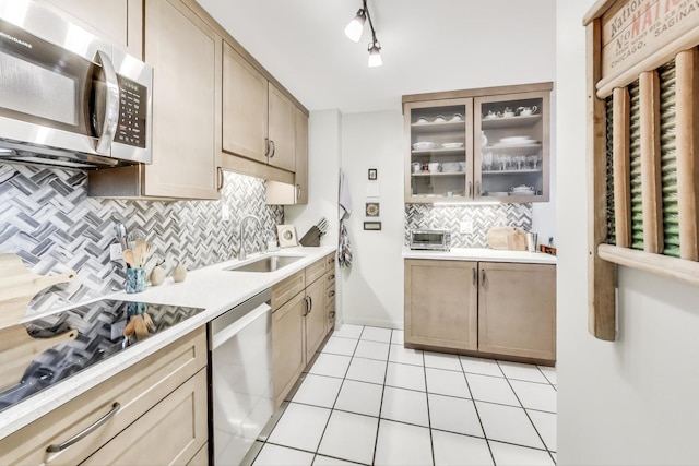 kitchen featuring stainless steel appliances, sink, backsplash, rail lighting, and light tile patterned floors