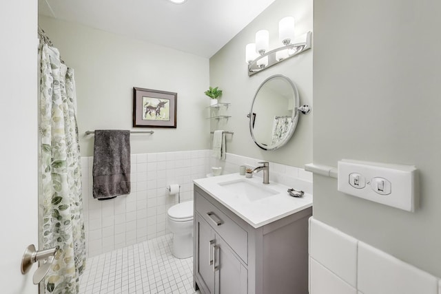 bathroom with tile patterned floors, tile walls, a shower with curtain, toilet, and vanity