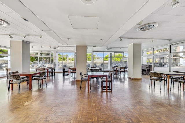 dining room with parquet floors and track lighting