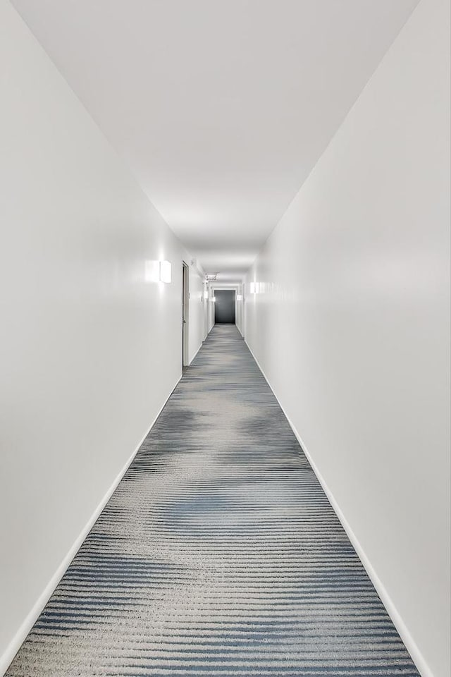 hall featuring dark colored carpet