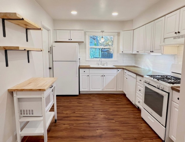 kitchen with white appliances, white cabinetry, butcher block counters, sink, and backsplash