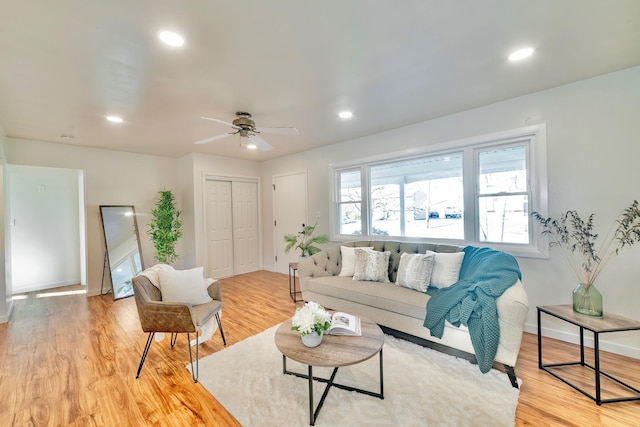 living room with ceiling fan and light hardwood / wood-style flooring