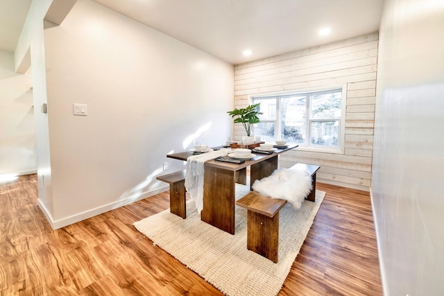 dining area featuring light hardwood / wood-style flooring and wooden walls