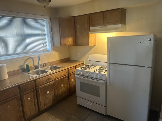 kitchen featuring dark tile patterned floors, sink, and white appliances