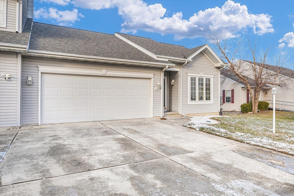 ranch-style house with a shingled roof, driveway, and an attached garage