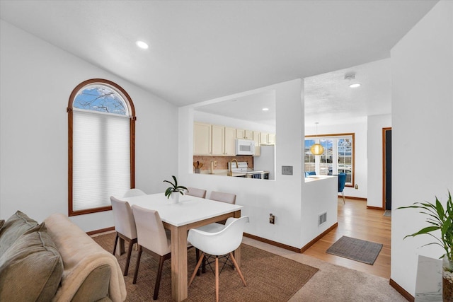 dining space featuring light wood-type flooring, plenty of natural light, visible vents, and recessed lighting