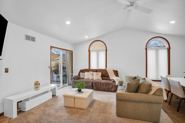 living room featuring light colored carpet, visible vents, plenty of natural light, and lofted ceiling