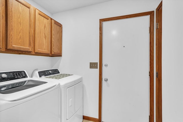 clothes washing area with washing machine and dryer and cabinet space