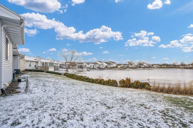 view of yard featuring a residential view, a water view, and central air condition unit