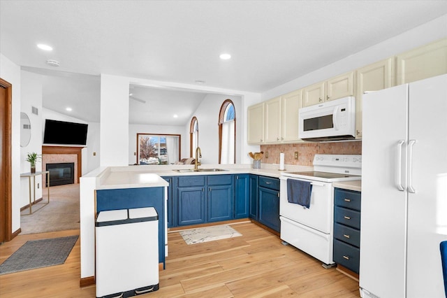 kitchen with light wood-style flooring, blue cabinets, a peninsula, white appliances, and open floor plan