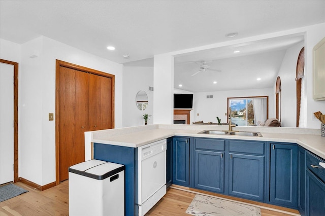 kitchen featuring blue cabinets, a sink, light wood-style flooring, and dishwasher