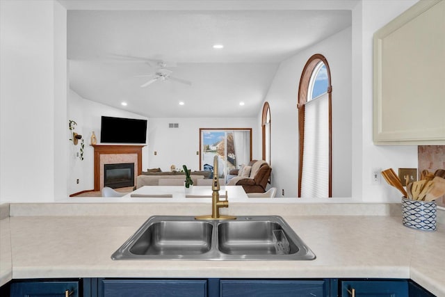 kitchen featuring blue cabinetry, open floor plan, a sink, and light countertops