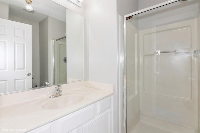 bathroom featuring vanity and a shower with shower door