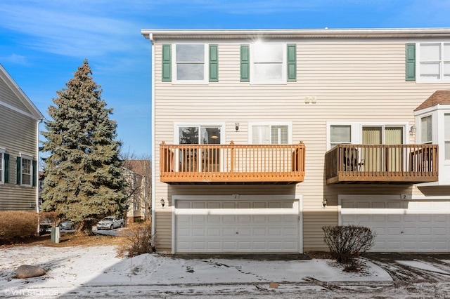 rear view of property with a garage and a balcony