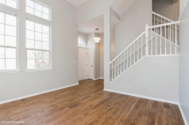 entryway with hardwood / wood-style flooring and a towering ceiling