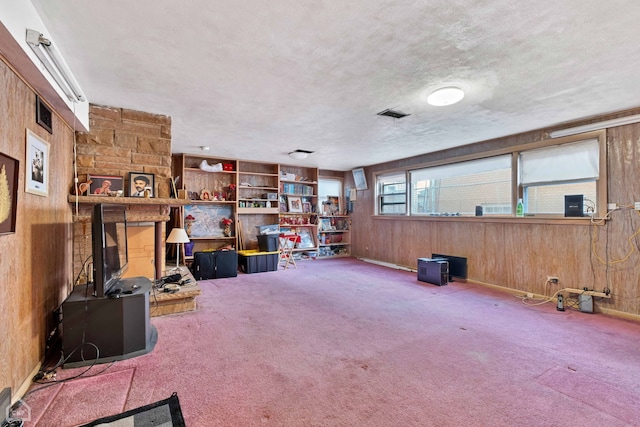 miscellaneous room featuring a textured ceiling, carpet, and wooden walls