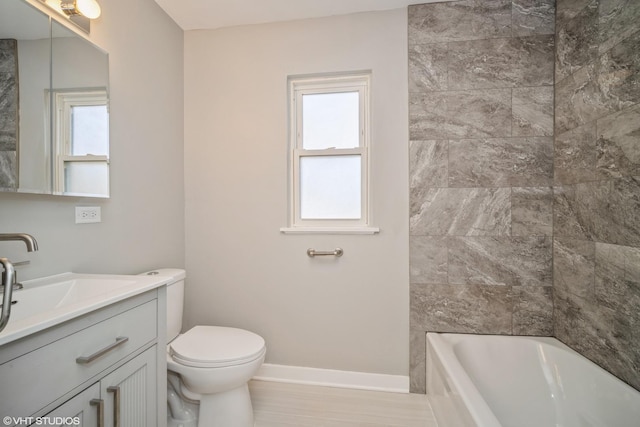 full bath with plenty of natural light, toilet, vanity, and baseboards