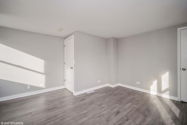 empty room featuring baseboards and wood finished floors