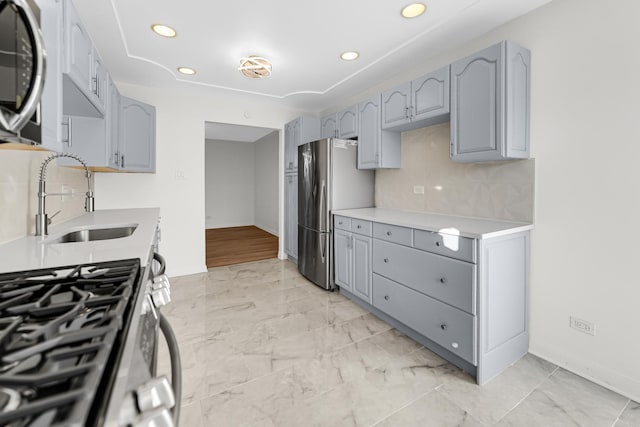 kitchen with appliances with stainless steel finishes, sink, and backsplash