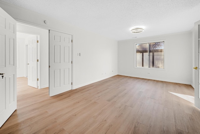 spare room featuring a textured ceiling and light wood-type flooring